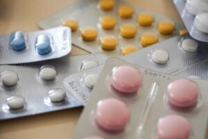 Assorted blister packs with colorful pills representing pharmacy stock and expiry tracking using HMIS systems
