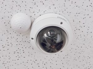 Ceiling‑mounted dome CCTV camera with sensor representing essential security infrastructure for hotels and restaurants in Kenya.