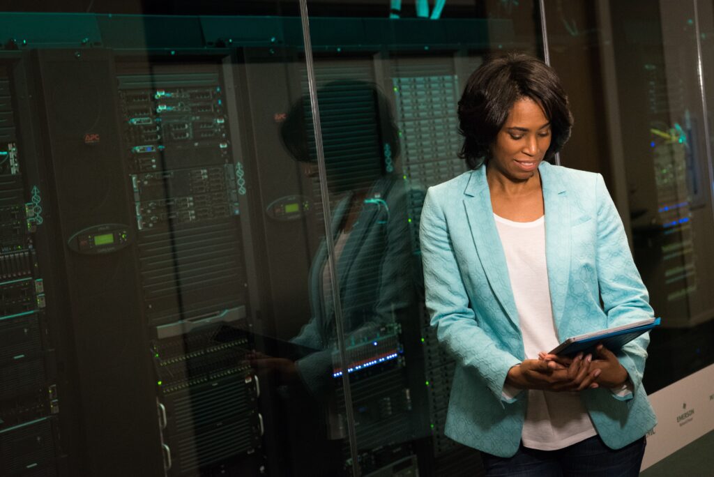 Professional with tablet analyzing server racks representing HMIS infrastructure in Kenya