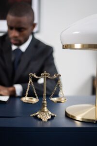 Brass balance scale on desk with suited professional symbolizing IT support and client data protection for law firms in Kenya.