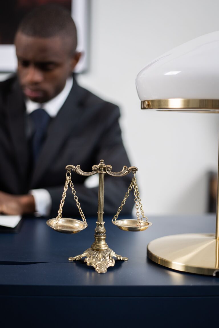 Brass balance scale on desk with suited professional symbolizing IT support and client data protection for law firms in Kenya.
