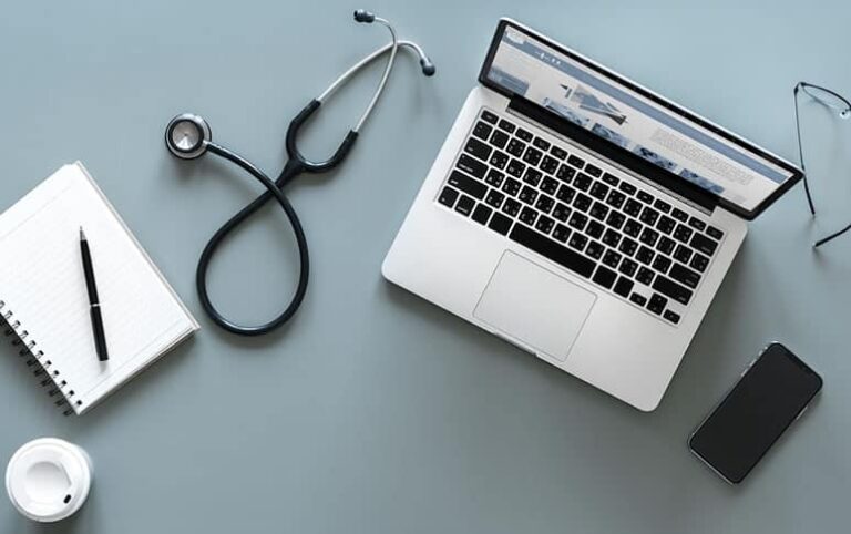 Flat lay of laptop, stethoscope, smartphone, and notebook symbolizing managed IT support for hospitals and clinics in Kenya.