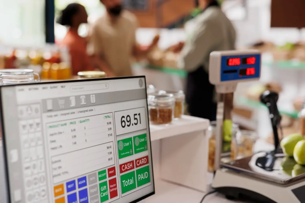 Retail checkout counter with POS screen and scale representing integration of M‑Pesa payments for Kenyan shops.