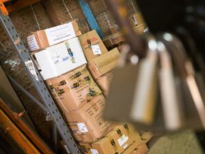Warehouse shelves with medical supply boxes and padlocks symbolizing stock security and theft prevention in retail stores